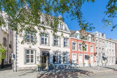 Front view of Amrâth Hotel Bigarré in Maastricht, historic building with white and red facades in a row of townhouses.